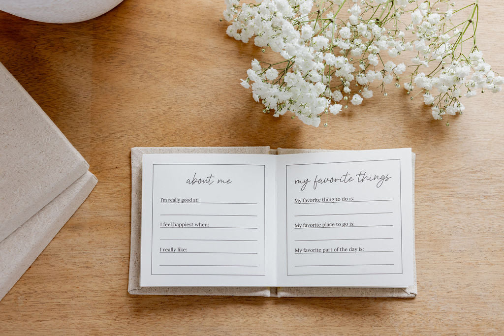 Open book with questionnaire pages on a wooden surface with white flowers.